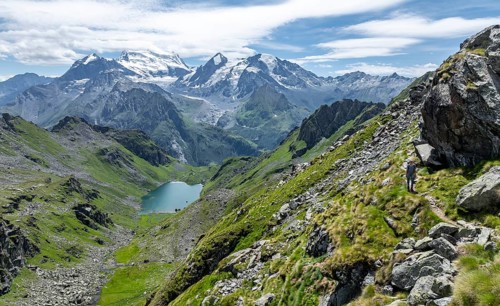 Mountain stream and mountain lake Lac de Louvie with glaciated summit of the Grand Combin, Val de