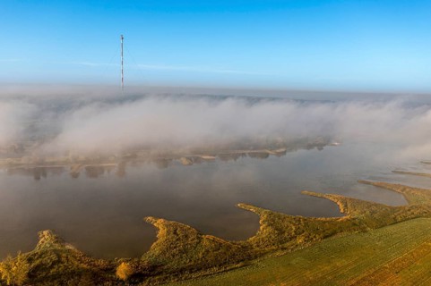 Aerial view of river Elbe near Lenzen, view to Höhbeck radio mast, morning fog in autumn, Germany,