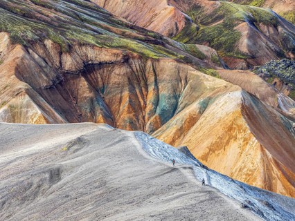 Hikers decending the slopes of Mt. Blahnukur, colorful rhyolite mountains, lava field,