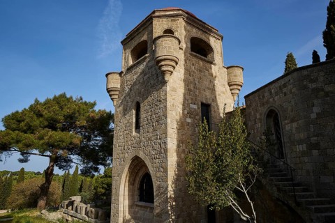 St John's Church, Historic stone tower with windows and stairs, surrounded by trees under a clear