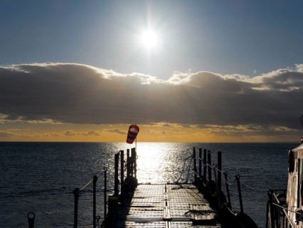 Jetty at sunrise over the sea on the Strait of Magellan, Punta Arenas, Chile, South America