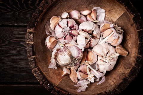 Fresh garlic, in a wooden plate, top view, close-up, no people