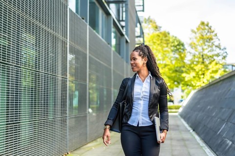 Horizontal photo with copy space of a modern latin businesswoman walking out the block office