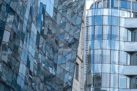 Reflective glass facades of modern office buildings with curved shapes and urban ambience, Skopje,
