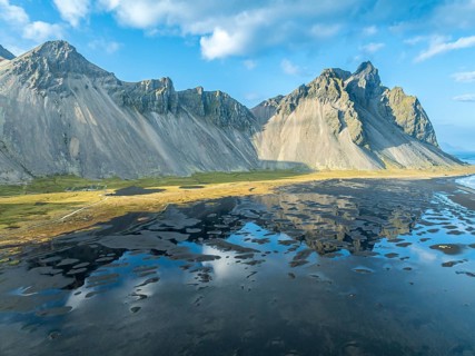 Aerial view of Mt. Vestrahorn, black lava beach, reflections on the water, Stokksnes, east of Höfn,