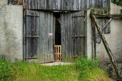 Weathered wooden barn door with the sign NO ACCESS, on a hiking trail above Merano in the