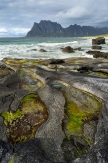 Seascape on the beach at Uttakleiv (Utakleiv), in the foreground rocks and rocky outcrops filled