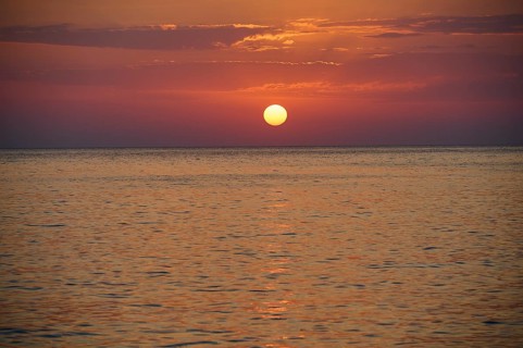 Sunset over the calm sea under an orange sky, Mandraki, Nisyros, Dodecanese, Greek Islands, Greece,