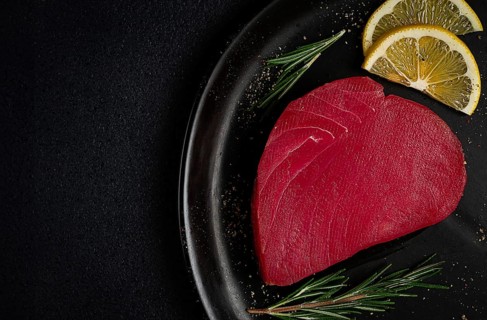 Fresh red tuna fillet, for steak, raw, top view, on a black plate, no people
