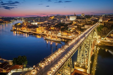 View of illuminated Porto city and Douro river and Dom Luis bridge I from famous tourist viewpoint