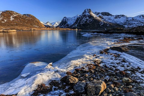 Sunrise, morning light, steep mountains and fjord, ice, winter, Flakstadoya, Lofoten, Norway,