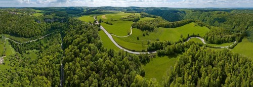 Winding country road through a forest, Swabian Alb in spring, panoramic photo, drone photo,
