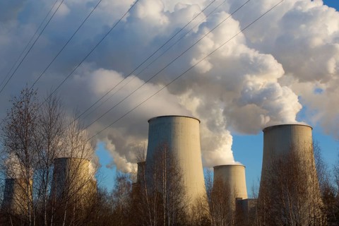 Steam rises from the cooling towers of the Vattenfall power plant in Jänschwalde, power lines and