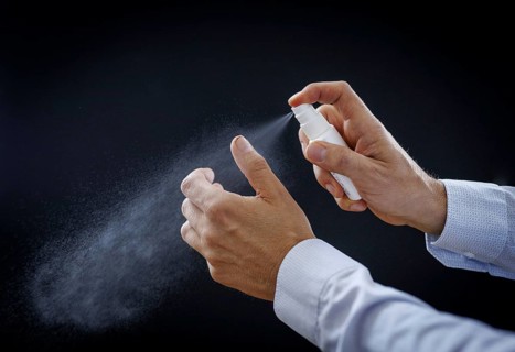 A man sprays wound disinfectant on his thumb in Berlin, 09/08/2024