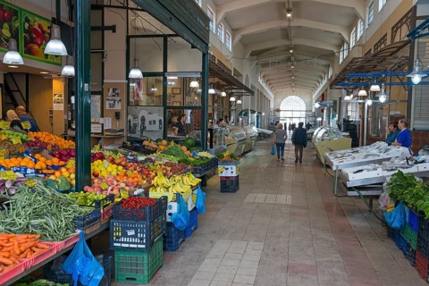 A market hall with various colourful fruit and vegetable stalls and people shopping, Xanthi,