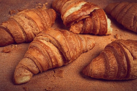 Fresh croissants, breakfast, top view, on the table, brown background, no people