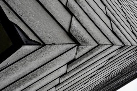 Close-up of an architectural façade with geometric design in grey tones