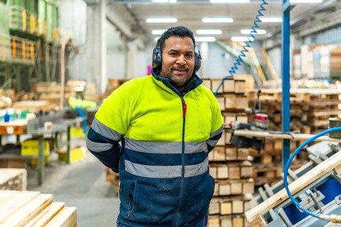 Portrait of a manual worker in a recycling plant next to pallets to arrange and reuse