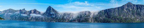 Panorama of fjord Mefjord with famous peaks Hesten, Segla and Grytetippen, salmon farm, Senja