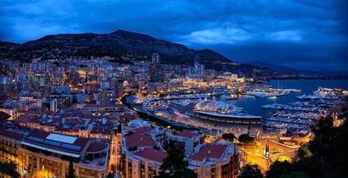 Aerial panorama of Monaco Monte Carlo harbour and illuminated city skyline in the evening blue hour