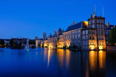 View of the Binnenhof House of Parliament and the Hofvijver lake with downtown skyscrapers in
