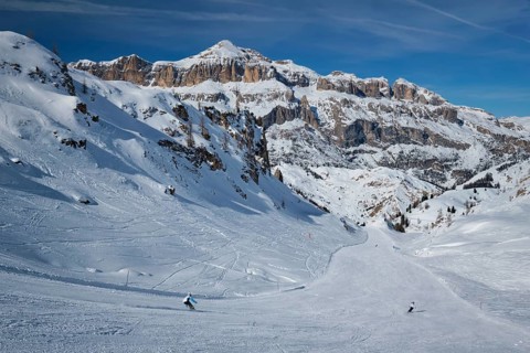 View of a ski resort piste with people skiing in Dolomites in Italy. Ski area Arabba. Arabba,