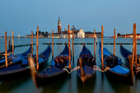 Venetian gondolas near St. Mark's Square in the evening light, blue hour, in the background the