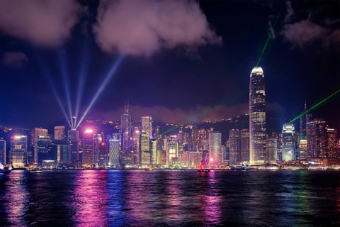 Hong Kong skyline cityscape downtown skyscrapers over Victoria Harbour in the evening illuminated