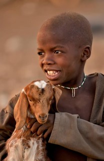 Himba boy with a goat, Ombombo, Kaokoland, Kunene, Namibia, Africa