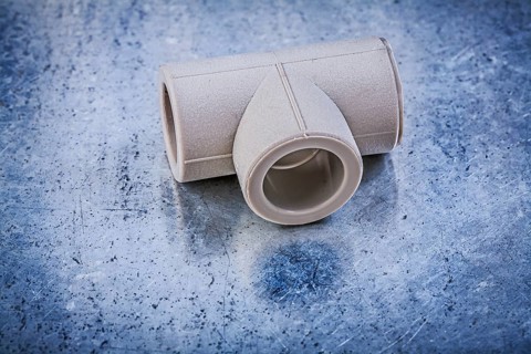 Plastic T-tube on metallic background construction concept