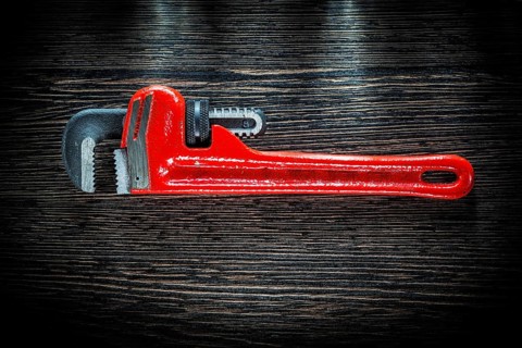 Pipe wrench on vintage wooden board