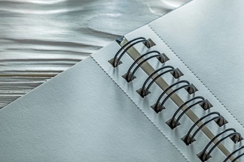 Spiral notebook on white wooden board