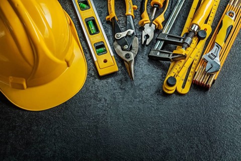 Set of yellow construction tools on black background