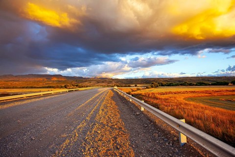 Gigantic scenic thundercloud permeated by lightning strikes and illuminated by the sunset. The