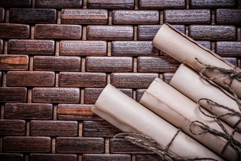 Rolled vintage documents on wicker wooden matting