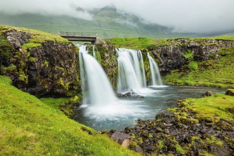 Iceland - country of mountains, rivers and waterfalls. Threaded full-flowing waterfall on the