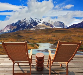Pleasant holiday. Wooden chairs in the park Torres del Paine. Chile. On the horizon is visible
