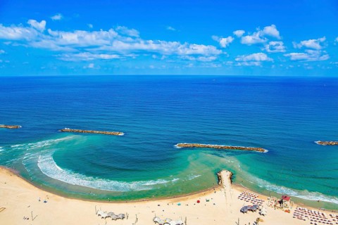 Magnificent sandy beach in Tel Aviv. Photo taken from the roof of a high-rise hotel. The blue