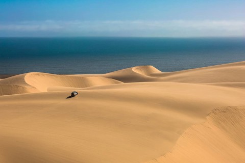 Gorgeous and dangerous jeep - safari through the huge sand dunes on the ocean coast. The concept of