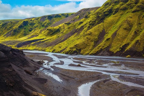 Canyon Pakgil in Iceland. Picturesque basalt hills covered with green grass and moss-polar. Streams