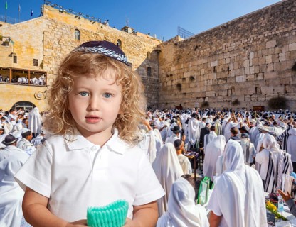 Llittle Jewish boy with side curls in yarmulke. Jews praying at the Western Wall. Ceremony at the
