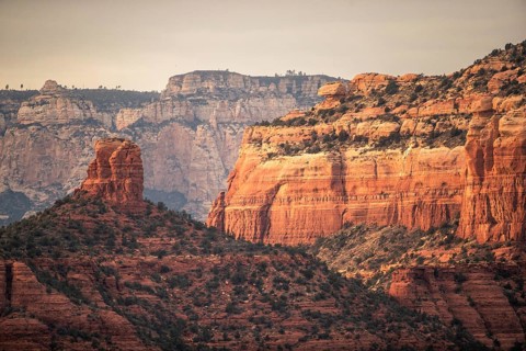 Majestic red rock formations and cliffs in a desert landscape under a clear sky in Sedona, Arizona,