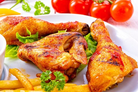Grilled chicken wings, legs, chips and vegetables
