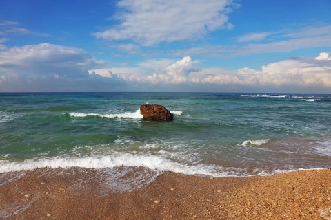 Huge stone in surf waves. Picturesque coast Mediterranean sea, Israel, Asia