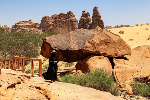 Guide in Jebel or Jabal Ikmah shows large open library, rock bands with petroglyphs, rock carvings