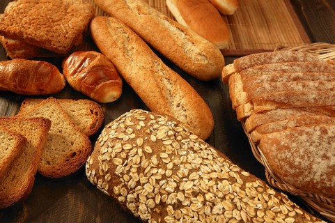 Varied bread still life over dark wood background