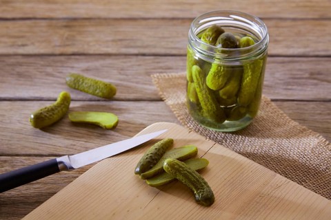 Bottled pickles cucumbers in vintage wooden table