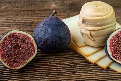 Figs, various cheese on a rustic table.Traditional hand made slovak smoked cheese parenica. Healthy