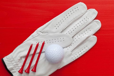 Golf equipments on the wooden red table