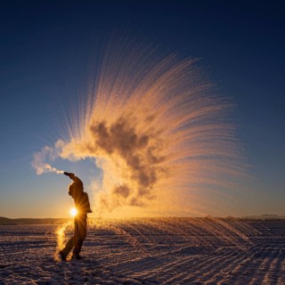 Woman throws hot water into the air that freezes into ice crystals, Mpemba effect, Unterallgäu,